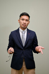 Angry and unhappy millennial Asian businessman opening his palm, and looking at the camera