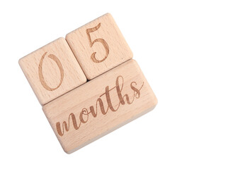 A wooden block showing the date of birth of a newborn child on a white background.