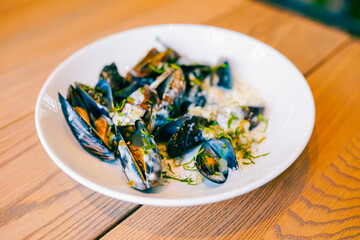 Close up of freshly cooked mussles in a plate with ingredients