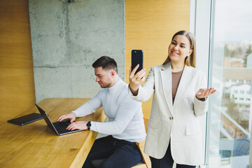 Colleagues while working with a laptop in the office. Two goal-oriented entrepreneurs collaborate in a modern workspace. Two young businessmen work in a bright office