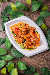 wok fried red sweet and sour spicy sauce with big prawn  and cucumber on wood table chinese banquet seafood halal menu