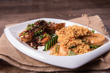 two in one varieties wok fried big prawn with nonya sweet and sour dark sauce and cereal butter prawn with curry leaf on wood table chinese halal banquet seafood menu