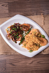 two in one varieties wok fried big prawn with nonya sweet and sour dark sauce and cereal butter prawn with curry leaf on wood table chinese halal banquet seafood menu