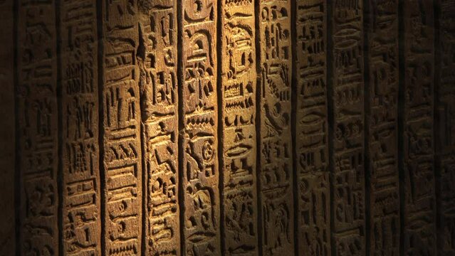Light spot moving on ancient egypt hieroglyphics carving on wall of temple, 4k