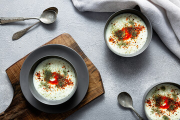 3 bowls of traditional yogurt soup known as yayla corbasi from Turkish cuisine on textured...