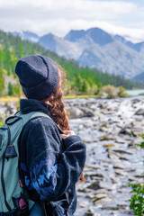 Young woman with backpack enjoys the view of nature at hike