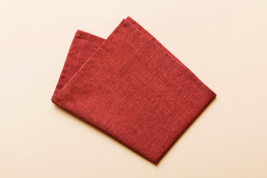 top view with red empty kitchen napkin isolated on table background. Folded cloth for mockup with copy space, Flat lay. Minimal style