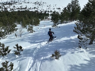 Cinematic downhill freeride skiing of two professional ski mountain guides in fresh deep snow with amazing mountain landscape. Freeride athletes showing off piste ski turns with awesome panorama view