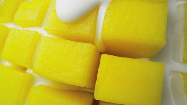 Macro video of mango covered with yoghurt. Shot with RED helium camera in 8K.  