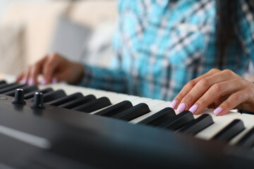 Obraz premium Woman hands playing electric piano at home performing musical composition closeup