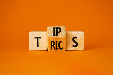 Tips and Tricks symbol. Turned wooden cubes with words Tricks and Tips. Beautiful orange...