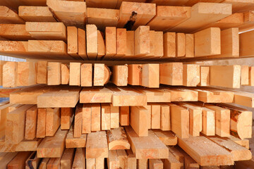 Stacked fresh wooden planks at a sawmill or warehouse.Storage of cutting boards in production.A stack of wooden blanks, building material.Improper storage of boards outdoors.Wood processing