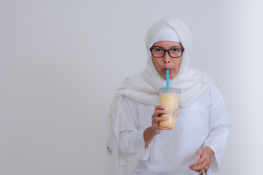 A young woman is having a drink to break her fast.