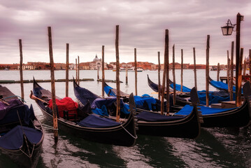 Fototapeta na wymiar Gondolas in Venice on sunset next to San Marco square. Famous landmark in Italy