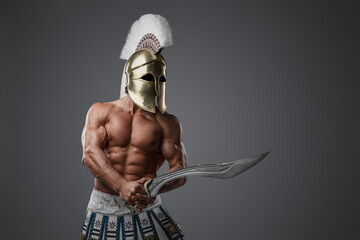 Portrait of shirtless greek soldier from past with strong body holding sword.