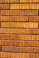 Brick wall with orange textured brick used for design or pattern purposes in urban or industrial...