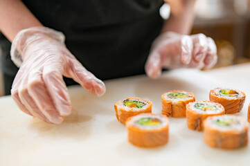 professional chef's hands making sushi roll in a restaurant kitchen