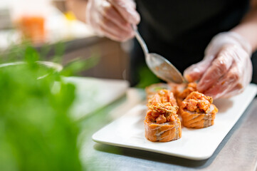 professional chef's hands making sushi roll in a restaurant kitchen