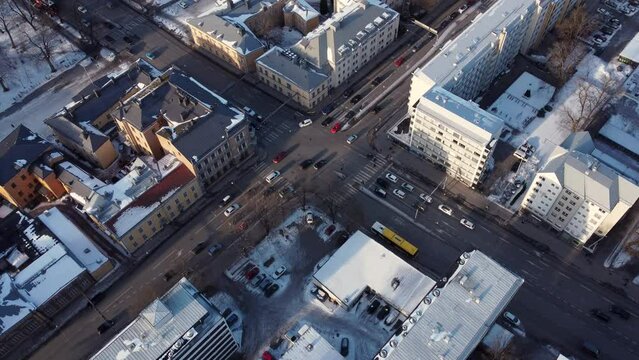 Afternoon traffic in a mid sized intersection near the city center. Dolly forward drone shot
