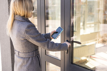 female entering secret key code for getting access and passing building using application on mobile phone, woman pressing buttons on control panel for disarming smart home system