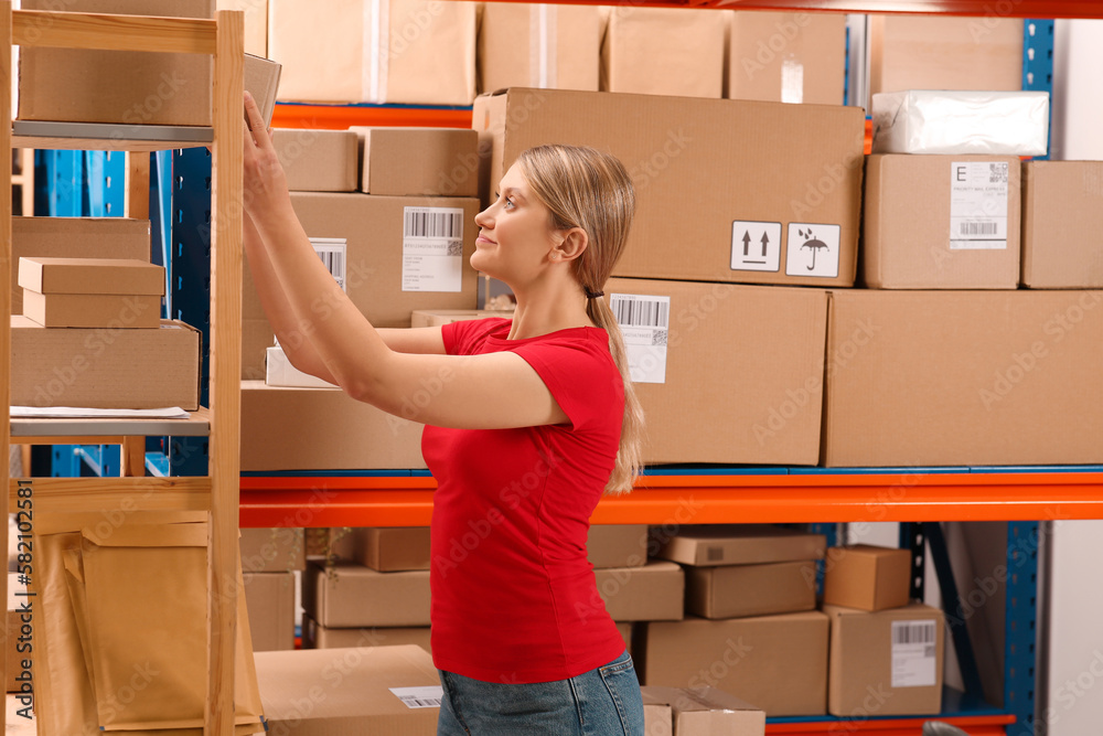 Canvas Prints Post office worker near rack with parcels indoors