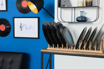 Vinyl records on wooden stand in living room
