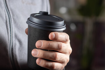 Man drinking coffee from disposable cup with cocktail tube close up