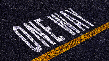 One way text written and yellow line on the road in middle of the asphalt road, One way word on...