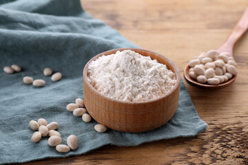 Fototapeta na wymiar Kidney bean flour and seeds on wooden table, closeup