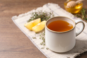 Aromatic herbal tea with thyme on wooden table, space for text