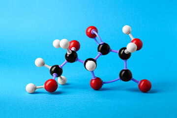 Molecule of vitamin C on light blue background. Chemical model