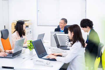 楽しくオフィスで仕事をするスタッフ