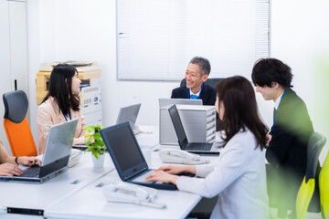 楽しくオフィスで仕事をするスタッフ