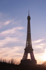   Front view, far distance of, a silhouette of the Eiffel Tower, against a cold, November, blue sky