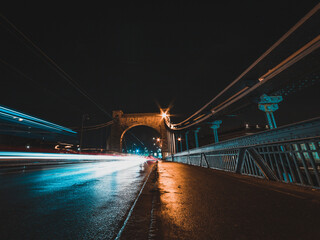 bridge at night with vehicles light trails