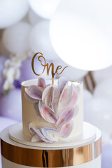 Birthday cake with the inscription one. Exquisite cake on the background of the photo zone.