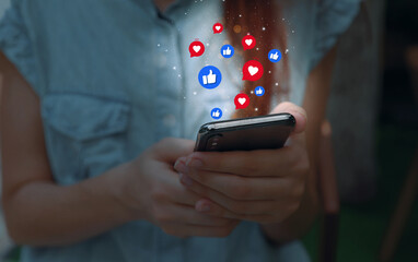 Social media interactions on mobile phone, concept with notification icons of like, message, email, comment and star above smartphone screen, person hands holding device, internet digital marketing
