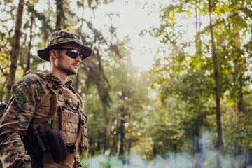 Obraz premium Soldier portrait with protective army tactical gear and weapon having a break and relaxing