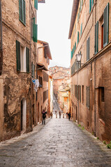 Old narrow street in the city of Siena, Tuscany, Italy