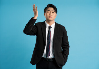 Portrait of young businessman posing on blue background