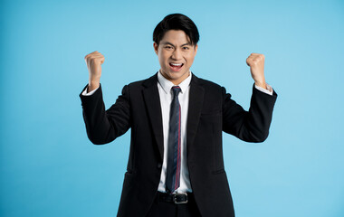 Portrait of young businessman posing on blue background