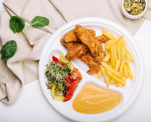 Chicken nuggets with french fries and mustard sauce