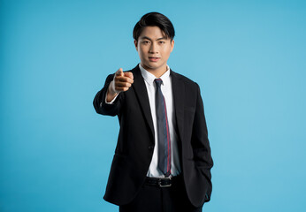 Portrait of young businessman posing on blue background