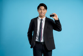 Portrait of young businessman holding bank card in hand