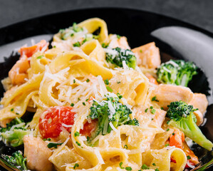 italian fettuccine alfredo pasta dish with grilled salmon and broccoli