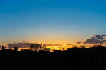 Sunset with rural landscape silhouette and golden blue sky