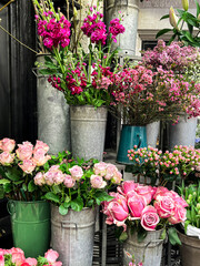 Fototapeta na wymiar Bright flower stalls somewhere in London. Roses, tulips, and all other vibrant flowers placed in buckets and bouquets. These are the beauty for the eye.