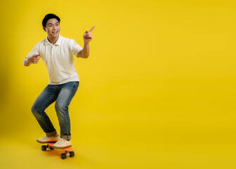 Fototapeta na wymiar image of young asian male playing skateboard on a yellow background
