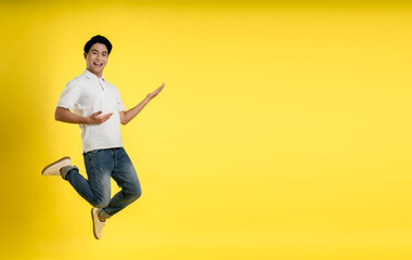 Full length image of young Asian man on yellow background