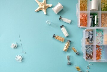 Women's hands make summer beaded earrings. Summer Costume jewelry. Do it yourself. Beads.
DIY. 